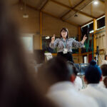 A female music teacher is conducting a primary school choir